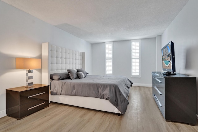 bedroom featuring light hardwood / wood-style floors and a textured ceiling