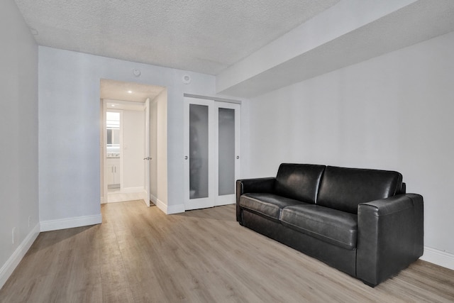 living room with light hardwood / wood-style floors and a textured ceiling