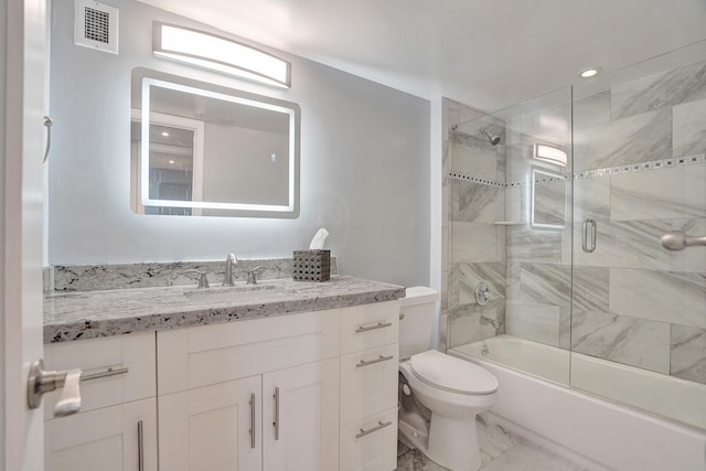 full bathroom featuring vanity, bath / shower combo with glass door, and toilet