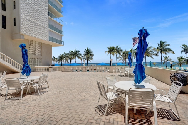 view of patio / terrace featuring a beach view and a water view