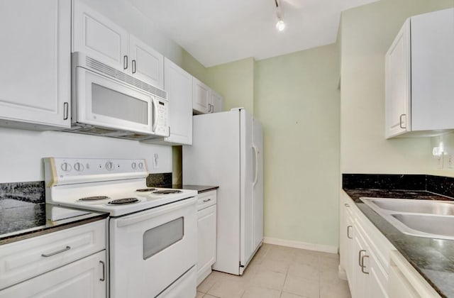 kitchen with light tile patterned floors, white appliances, white cabinetry, and sink