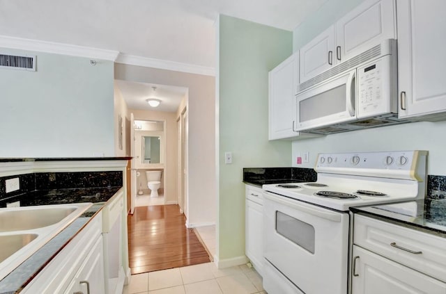 kitchen featuring white appliances, sink, crown molding, light wood-type flooring, and white cabinetry