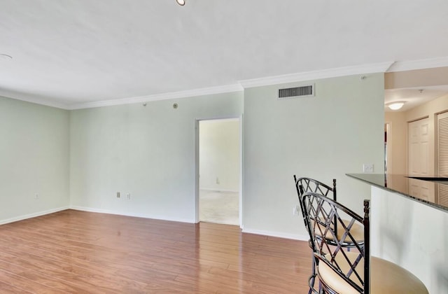 unfurnished room featuring light hardwood / wood-style floors and ornamental molding