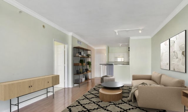 living room with crown molding, track lighting, and light wood-type flooring