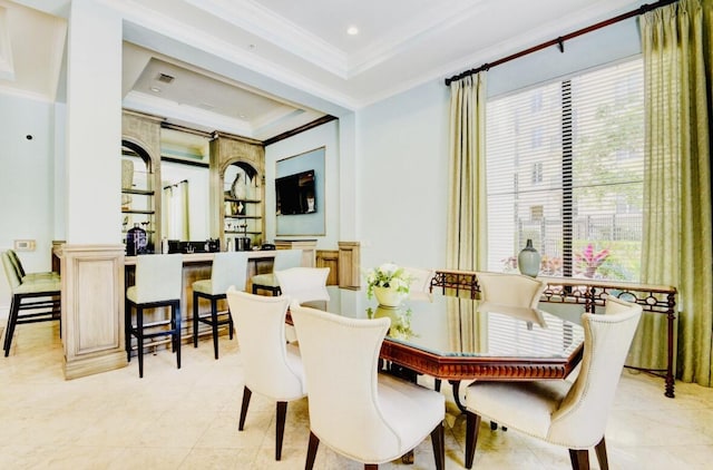 dining room with a raised ceiling and ornamental molding