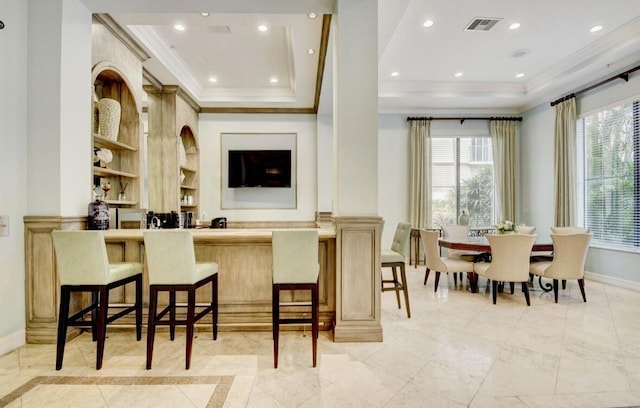 bar featuring a tray ceiling and ornamental molding