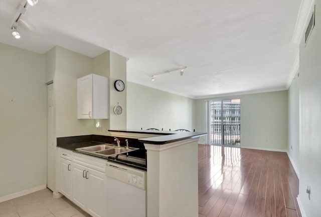 kitchen featuring white cabinetry, dishwasher, rail lighting, and sink