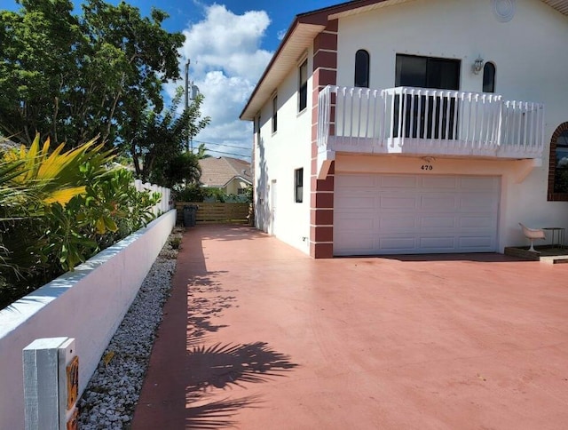 view of home's exterior with a garage and a balcony