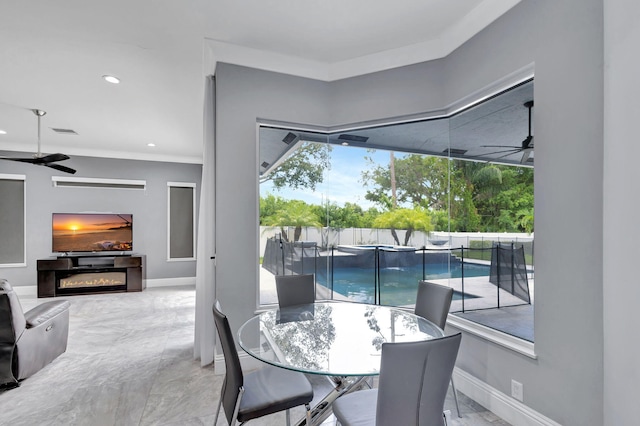 dining space featuring ceiling fan and ornamental molding