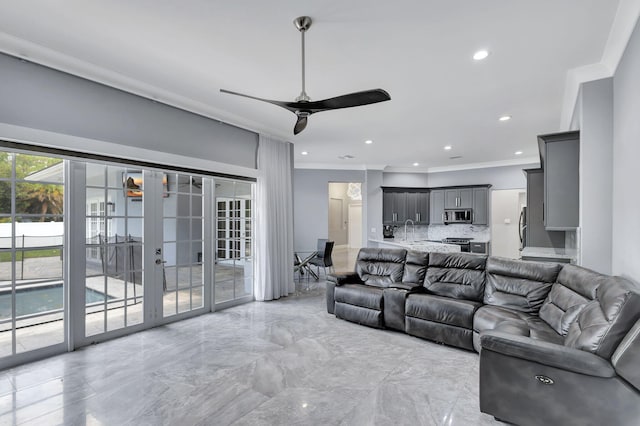 living room featuring ceiling fan, ornamental molding, sink, and french doors