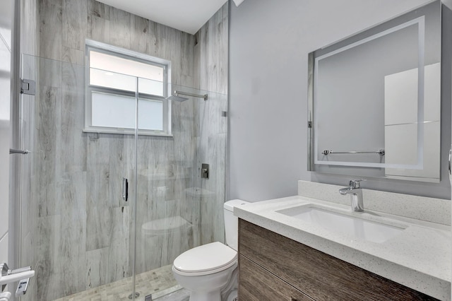 bathroom featuring an enclosed shower, vanity, and toilet