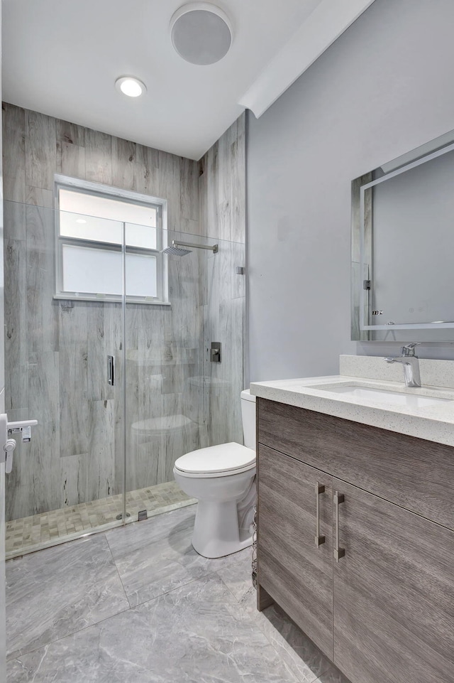 bathroom featuring an enclosed shower, vanity, and toilet