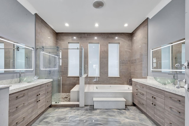 bathroom featuring vanity and independent shower and bath