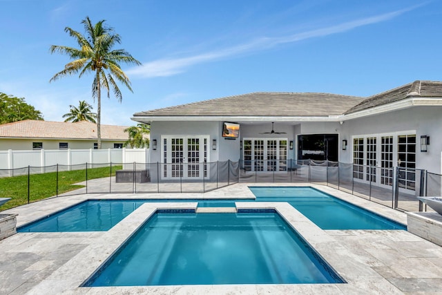 view of swimming pool with an in ground hot tub, french doors, a patio, and ceiling fan