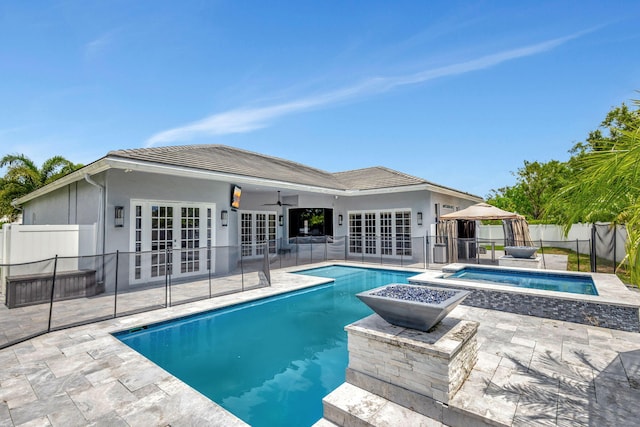 view of swimming pool featuring ceiling fan, an in ground hot tub, a patio, and french doors