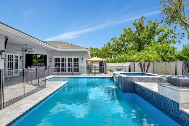 view of swimming pool featuring ceiling fan, french doors, a gazebo, a patio area, and an in ground hot tub