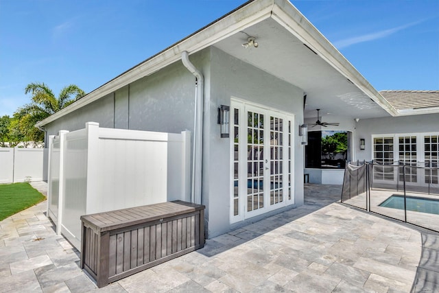 exterior space featuring ceiling fan, a fenced in pool, a patio, and french doors