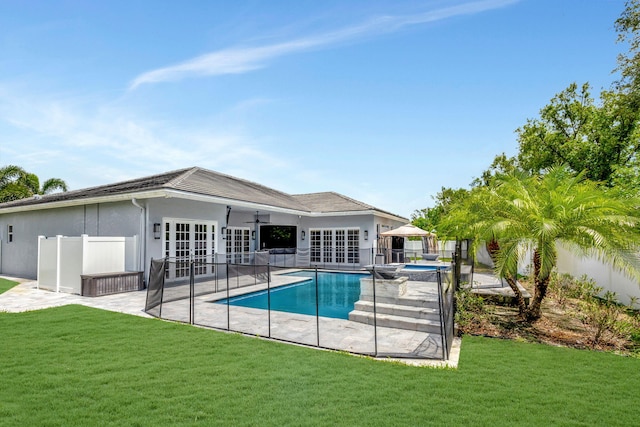 view of pool with a lawn, ceiling fan, a patio area, and french doors