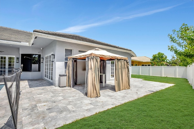 rear view of house with a gazebo, a patio area, and a yard