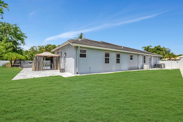 rear view of house featuring a gazebo, a patio area, a yard, and central AC