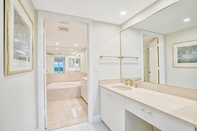 bathroom with tiled bath and vanity