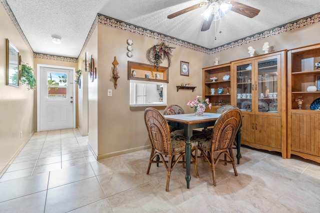 dining area with a textured ceiling, ceiling fan, and light tile patterned floors