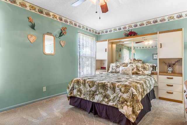 carpeted bedroom featuring a textured ceiling and ceiling fan