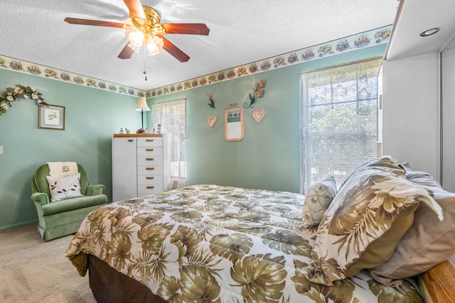 carpeted bedroom with ceiling fan and a textured ceiling