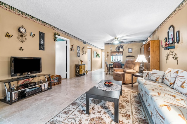 living room featuring a textured ceiling, ceiling fan, and tile patterned floors