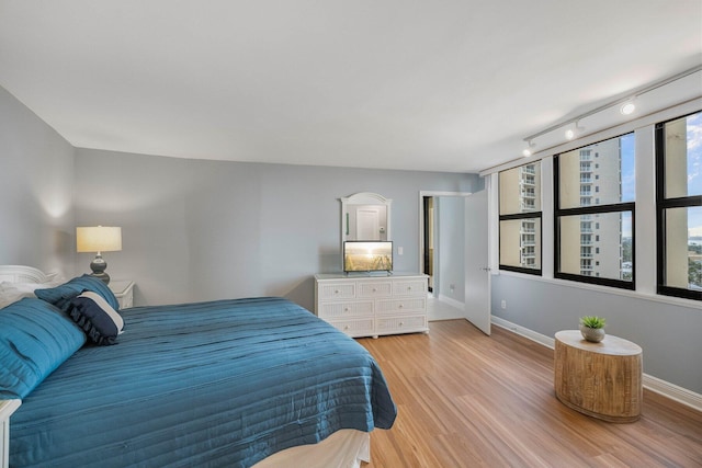 bedroom featuring track lighting and light wood-type flooring