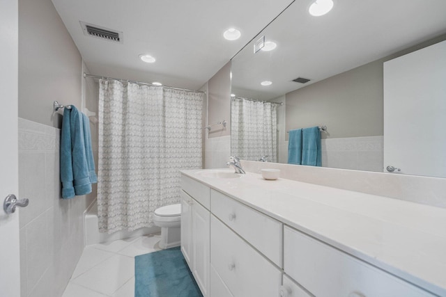 full bathroom with tile walls, shower / tub combo, vanity, tile patterned floors, and toilet