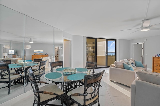 tiled dining room with floor to ceiling windows and ceiling fan