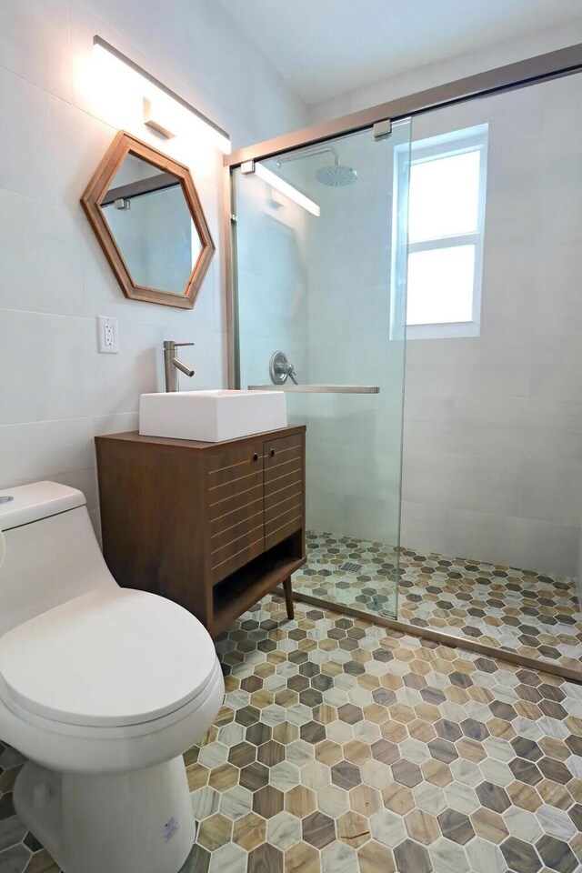 bathroom featuring an enclosed shower, vanity, and toilet