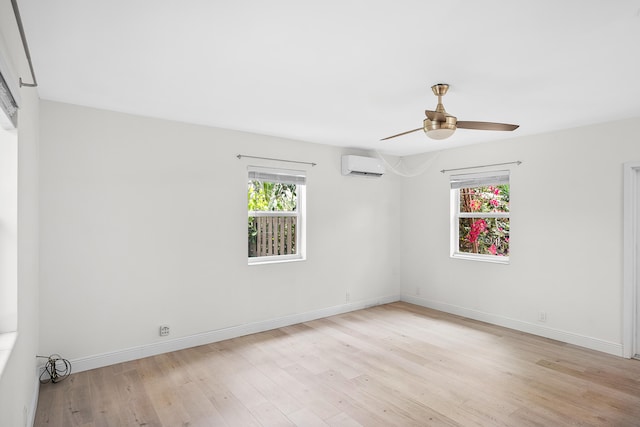 empty room with light hardwood / wood-style floors, ceiling fan, a healthy amount of sunlight, and an AC wall unit