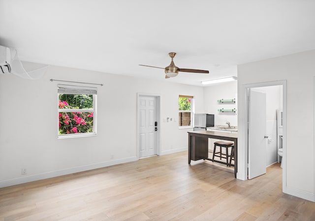 interior space featuring ceiling fan, light wood-type flooring, sink, and a wealth of natural light