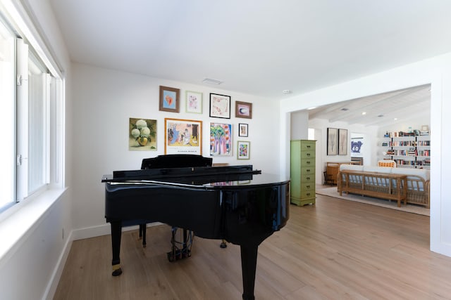 miscellaneous room with vaulted ceiling with beams and light hardwood / wood-style floors