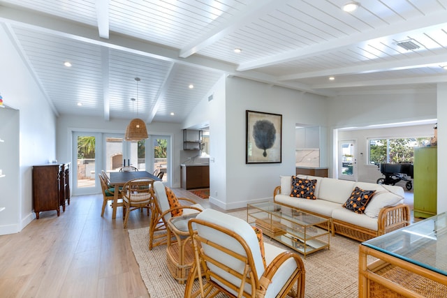 living room with vaulted ceiling with beams, plenty of natural light, and light wood-type flooring