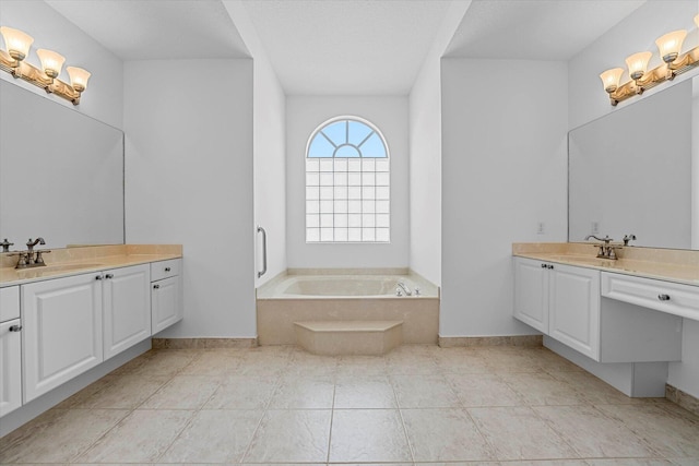 bathroom featuring tile patterned flooring, a relaxing tiled tub, a textured ceiling, and vanity