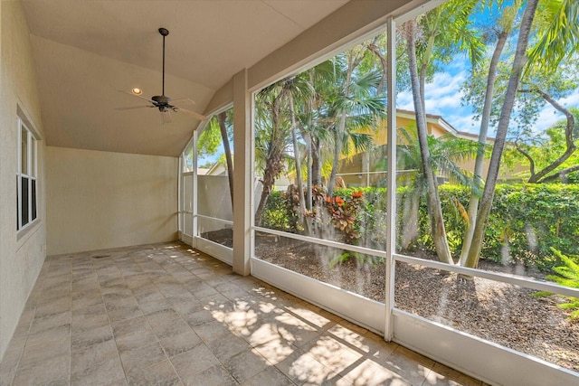 unfurnished sunroom with ceiling fan, a healthy amount of sunlight, and lofted ceiling