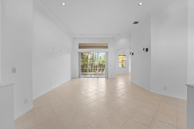 spare room featuring crown molding and light tile patterned floors