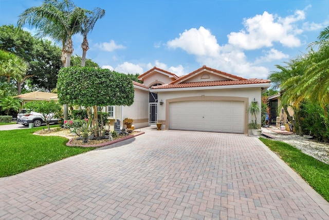 mediterranean / spanish house with a front lawn and a garage