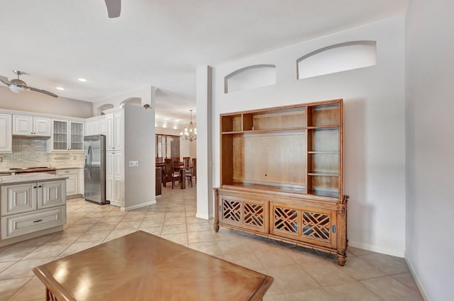 living room with ceiling fan with notable chandelier and light tile patterned floors