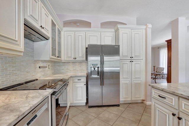 kitchen with decorative backsplash, light tile patterned flooring, white cabinetry, and appliances with stainless steel finishes