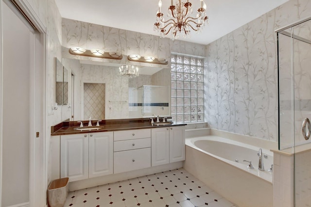 bathroom with shower with separate bathtub, vanity, and an inviting chandelier