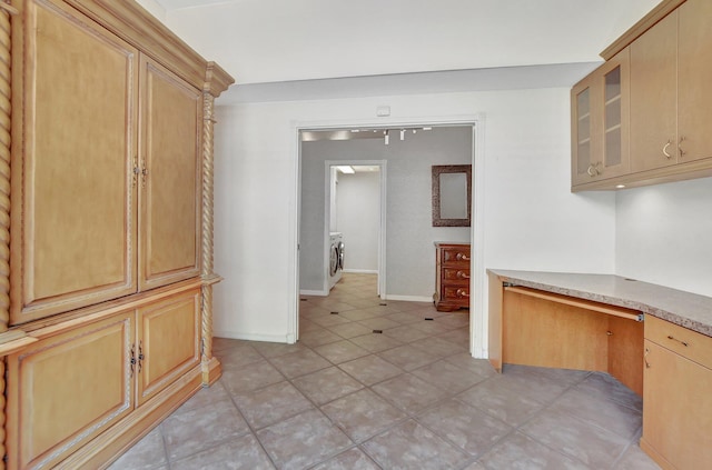 kitchen featuring light brown cabinetry, built in desk, and washer / clothes dryer