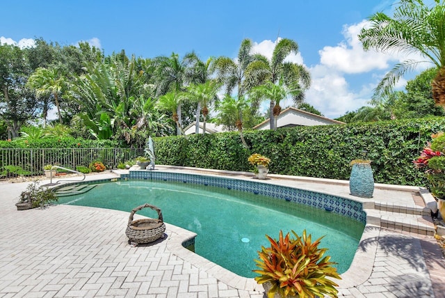 view of swimming pool with a fire pit and a patio area