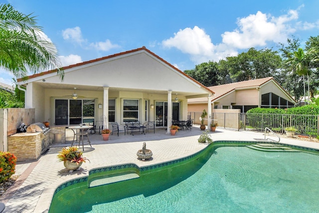 back of house featuring a fenced in pool, area for grilling, ceiling fan, and a patio area