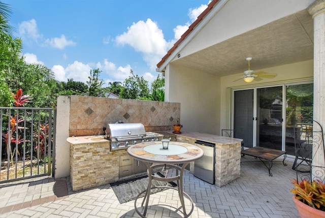 view of patio / terrace with a grill, ceiling fan, exterior bar, and an outdoor kitchen