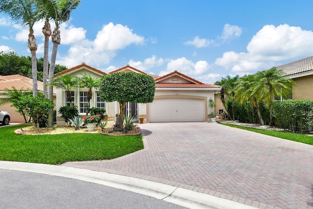 mediterranean / spanish house with a garage and a front lawn