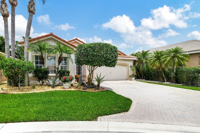 mediterranean / spanish house with a front yard and a garage